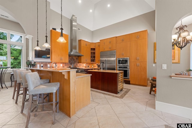 2001 Creek Rd Lot 16, Kitty Hawk, NC 27949 - kitchen featuring built in appliances, wall chimney range hood, light tile patterned flooring, backsplash, and arched walkways