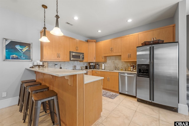 2001 Creek Rd Lot 16, Kitty Hawk, NC 27949 - kitchen featuring appliances with stainless steel finishes, a peninsula, decorative backsplash, light countertops, and hanging light fixtures