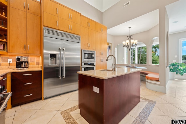 2001 Creek Rd Lot 16, Kitty Hawk, NC 27949 - kitchen with built in appliances, backsplash, light stone countertops, light tile patterned flooring, and a chandelier