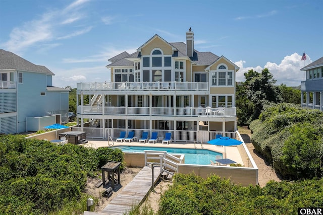 369 Deep Neck Rd Lot # 139, Corolla, NC 27927 - rear view of house with a patio, an outdoor pool, a balcony, a chimney, and roof with shingles