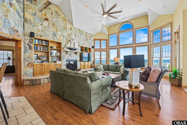 369 Deep Neck Rd Lot # 139, Corolla, NC 27927 - living area featuring a stone fireplace, ceiling fan, healthy amount of natural light, and high vaulted ceiling