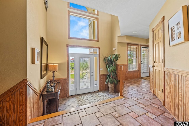 369 Deep Neck Rd Lot # 139, Corolla, NC 27927 - entrance foyer featuring a wainscoted wall, plenty of natural light, stone tile flooring, wooden walls, and a textured ceiling