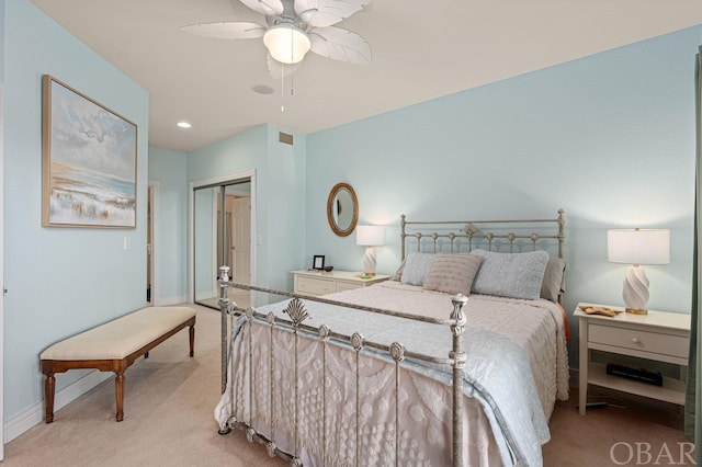 bedroom featuring baseboards, a closet, a ceiling fan, and light colored carpet