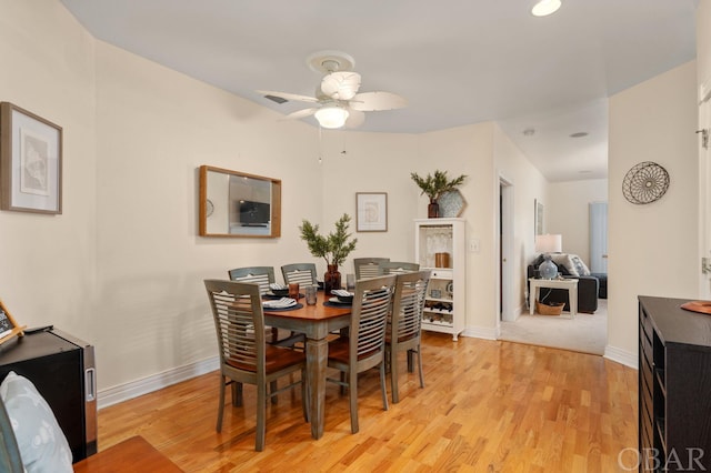 dining area featuring ceiling fan, light wood finished floors, and baseboards