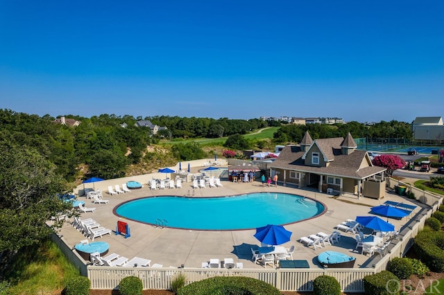 community pool with fence and a patio