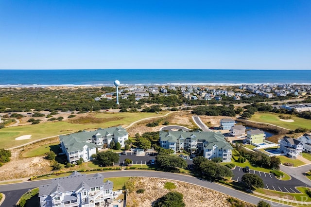 drone / aerial view featuring golf course view, a water view, and a residential view