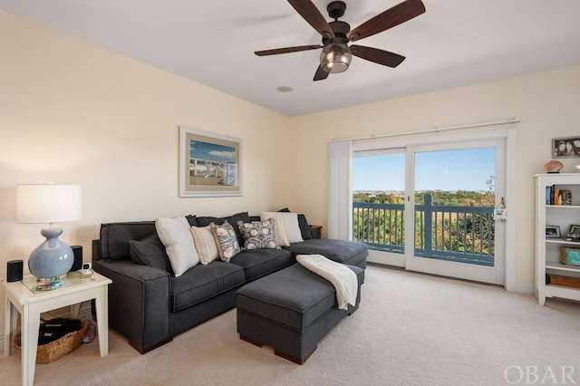 living area featuring light carpet and ceiling fan