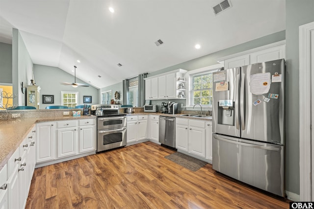 106 Flight Dr Lot 4, Duck, NC 27949 - kitchen with stainless steel appliances, wood finished floors, a ceiling fan, white cabinets, and recessed lighting