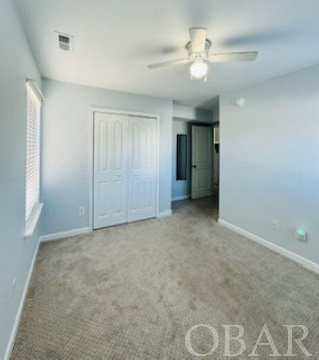 unfurnished bedroom featuring light colored carpet, visible vents, and baseboards