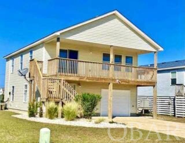 back of house with a garage, driveway, and stairway