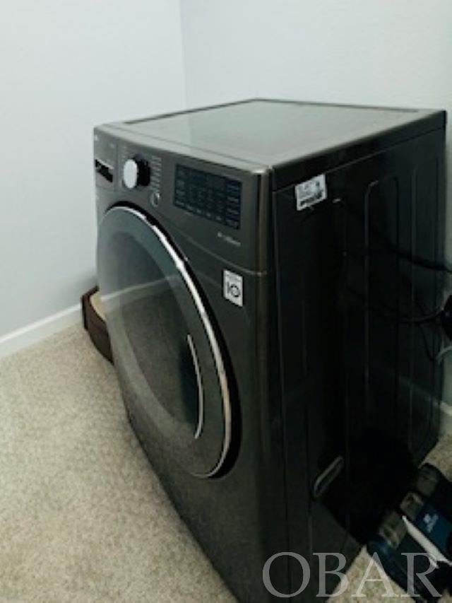 laundry area featuring laundry area, baseboards, and washer / clothes dryer