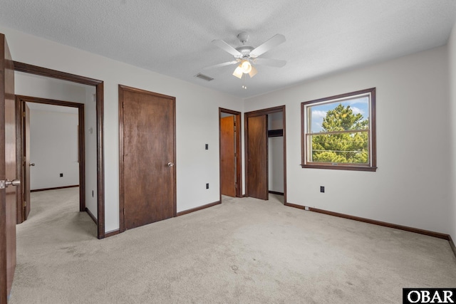 116 W Old Cove Rd Lot 1, Nags Head, NC 27959 - unfurnished bedroom with light carpet, a textured ceiling, baseboards, and multiple closets