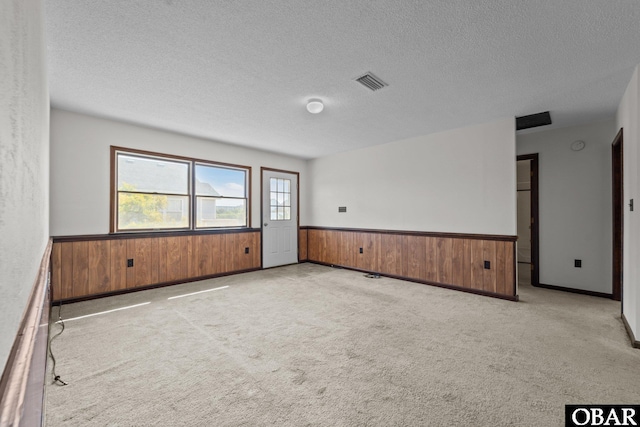 116 W Old Cove Rd Lot 1, Nags Head, NC 27959 - spare room with a wainscoted wall, a textured ceiling, wooden walls, and visible vents