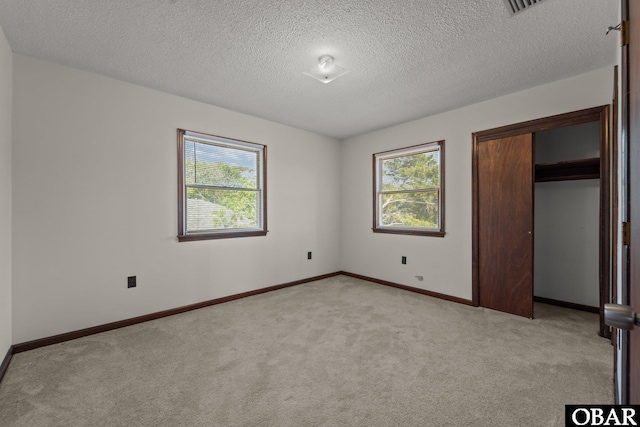 116 W Old Cove Rd Lot 1, Nags Head, NC 27959 - unfurnished bedroom with a textured ceiling, multiple windows, and light colored carpet