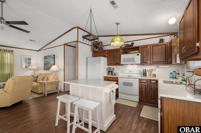 kitchen featuring visible vents, lofted ceiling, white appliances, dark wood-type flooring, and a sink
