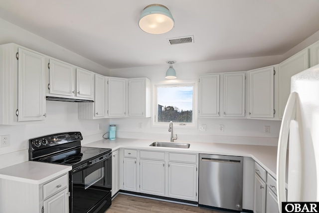 kitchen with visible vents, stainless steel dishwasher, freestanding refrigerator, electric range, and a sink