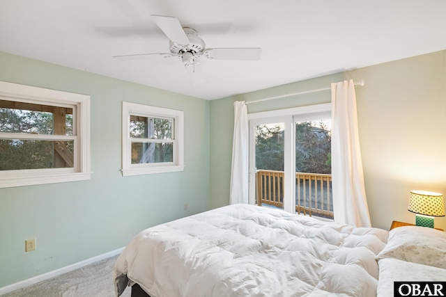 bedroom featuring multiple windows, access to outside, carpet flooring, and baseboards