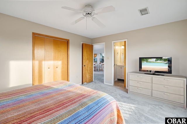 bedroom with visible vents, light carpet, ensuite bath, a closet, and ceiling fan