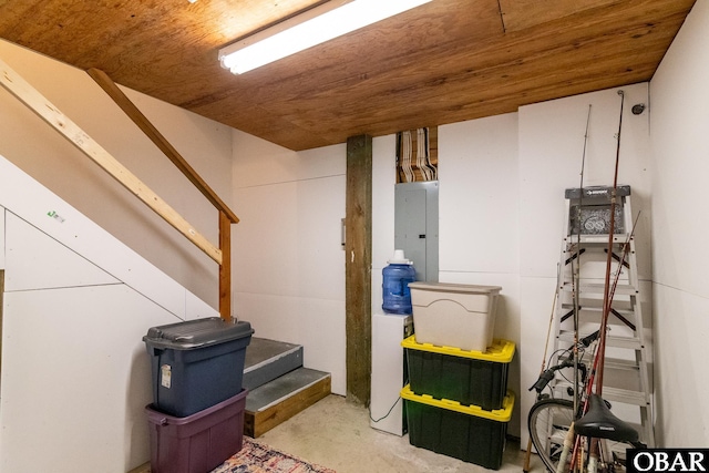 finished basement featuring electric panel, stairway, and wood ceiling