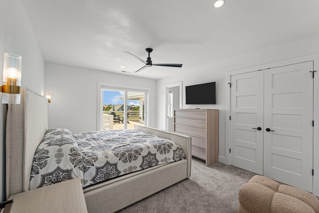 carpeted bedroom with access to exterior, a closet, a textured ceiling, and a ceiling fan