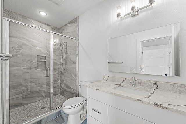 bathroom featuring marble finish floor, a stall shower, vanity, and toilet