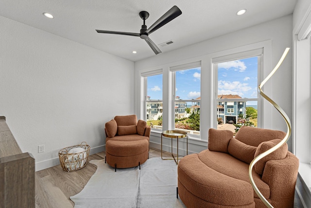 living area with baseboards, visible vents, wood finished floors, and recessed lighting