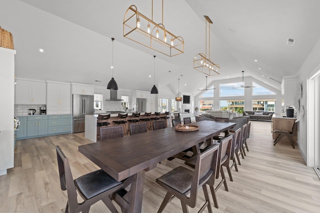 dining space featuring visible vents, plenty of natural light, light wood finished floors, and ceiling fan with notable chandelier