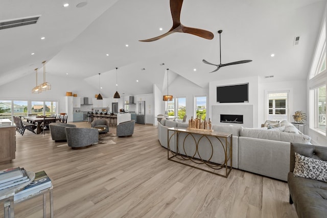 living room with a fireplace, a ceiling fan, and a healthy amount of sunlight