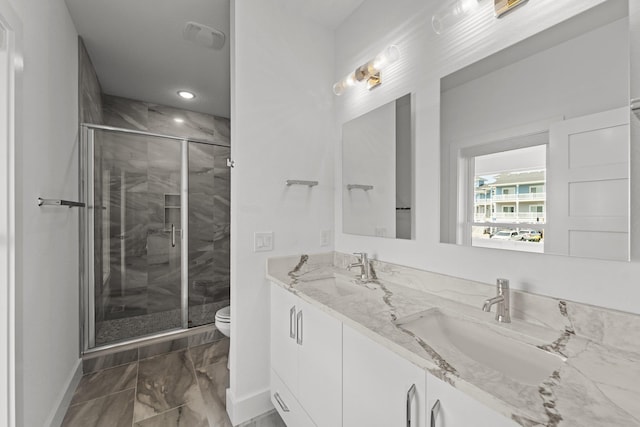 full bathroom featuring marble finish floor, a sink, a shower stall, and toilet