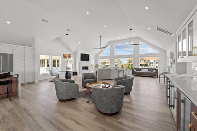 living area featuring a healthy amount of sunlight, ceiling fan, and light wood-style flooring