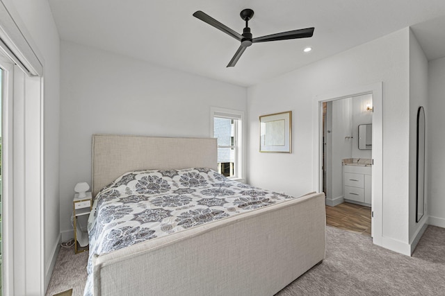 bedroom with carpet floors, ceiling fan, baseboards, and ensuite bathroom