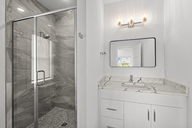 bathroom with a shower stall and vanity