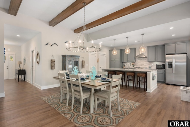 dining room with an inviting chandelier, beam ceiling, and dark wood-style flooring