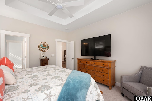 bedroom with carpet, a tray ceiling, and ceiling fan