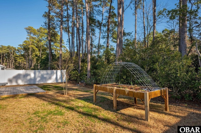 view of yard with a vegetable garden, fence, and a wooden deck