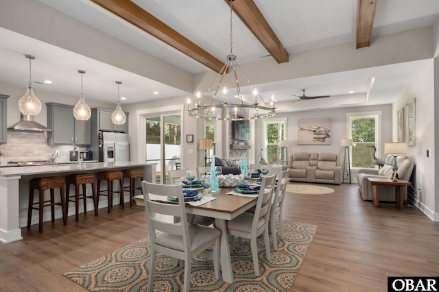 dining area with ceiling fan with notable chandelier, beamed ceiling, wood finished floors, and recessed lighting