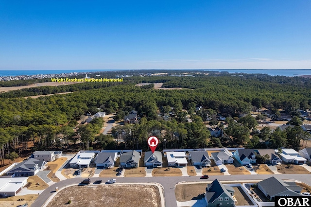 drone / aerial view with a water view, a residential view, and a wooded view