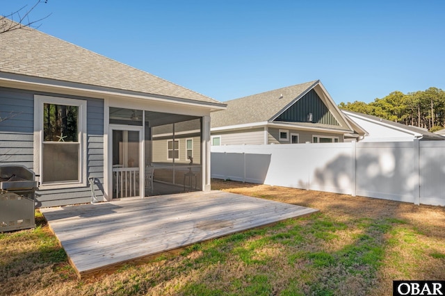 exterior space with a deck, a fenced backyard, and a sunroom