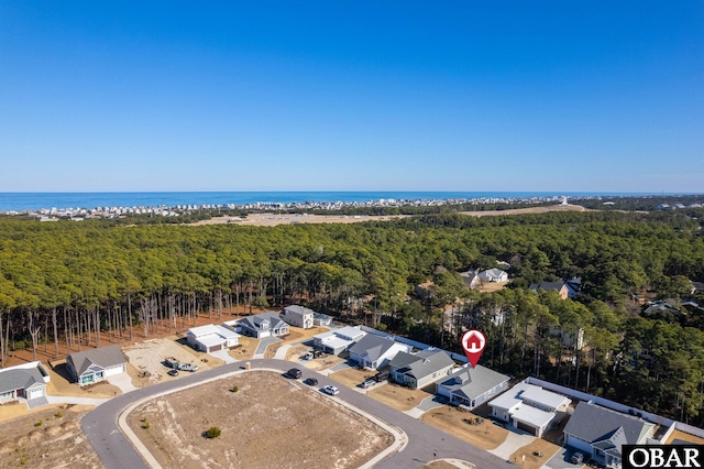 drone / aerial view with a water view and a wooded view