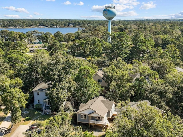 birds eye view of property featuring a water view and a wooded view