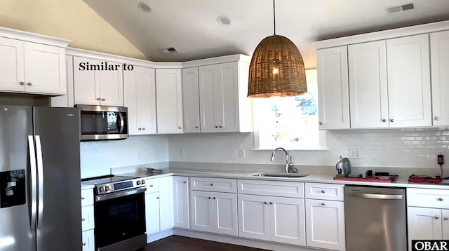 kitchen featuring stainless steel appliances, a sink, light countertops, and white cabinets