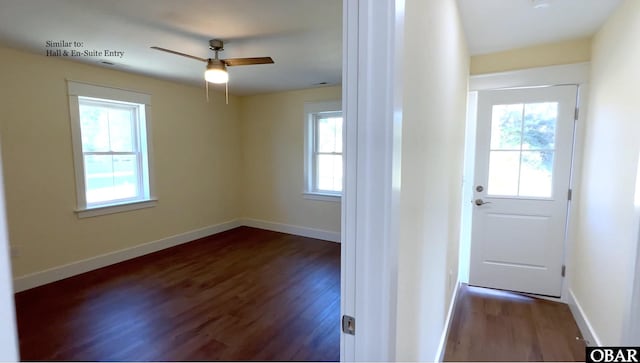 doorway featuring dark wood-style flooring, a ceiling fan, and baseboards