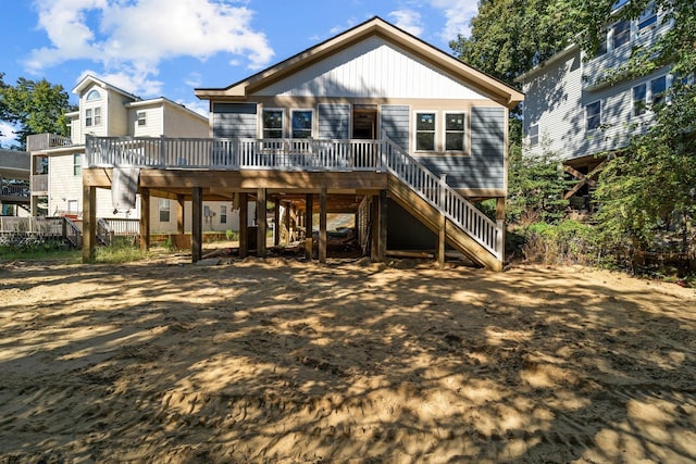 rear view of house featuring fence, stairway, and a deck