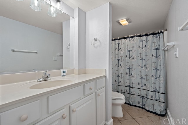 bathroom with toilet, vanity, and tile patterned floors