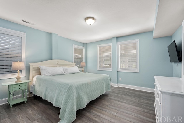 bedroom featuring dark wood-style floors, visible vents, and baseboards