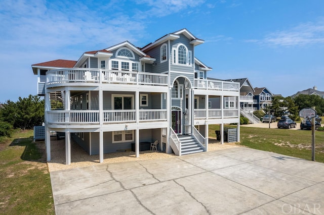 view of front of property featuring a balcony, driveway, and a front yard