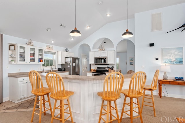 kitchen with stainless steel appliances, light countertops, visible vents, glass insert cabinets, and white cabinets