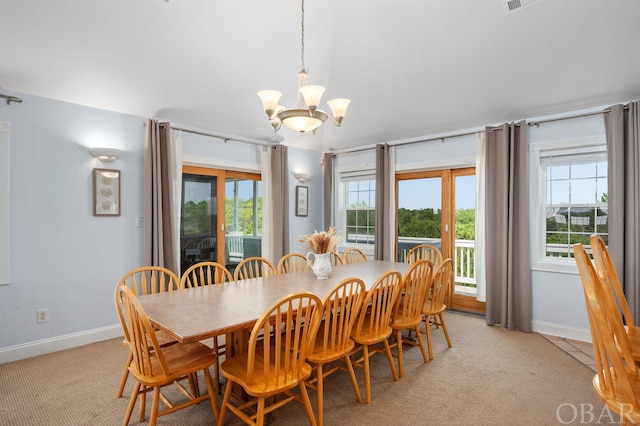 dining room with light carpet, plenty of natural light, a notable chandelier, and baseboards