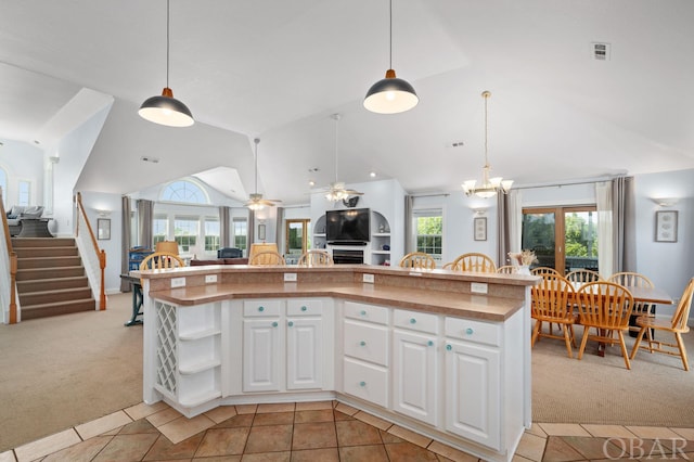 kitchen with a center island, light colored carpet, open floor plan, white cabinetry, and vaulted ceiling