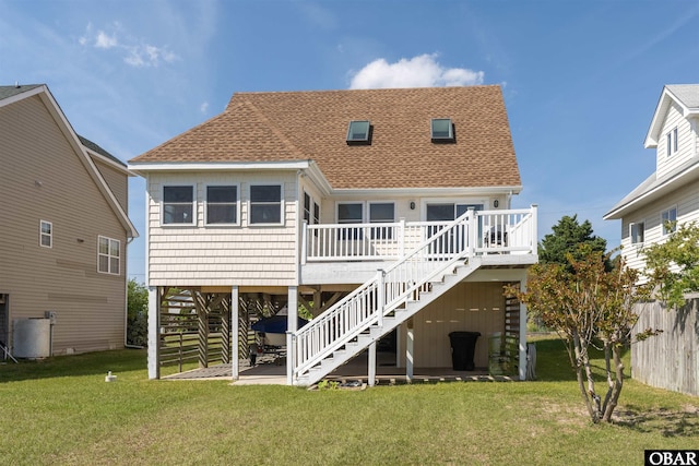 227 Outrigger Dr Lot 132, Kill Devil Hills, NC 27948 - back of house featuring fence, stairs, a deck, roof with shingles, and a lawn
